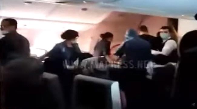 مسافر حاول فتح باب طائرة وكاد يتسبب بكارثة في الجو (فيديو)