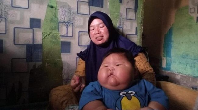 طفل ضخم بعمر 16 شهراً يرتدي ملابس والده